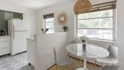 a kitchen with a table and a white refrigerator at Brickell Tree Apartment Beach 10min Location Shops in Miami