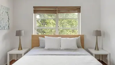 a bedroom with a bed with two lamps and a window at Brickell Tree Apartment Beach 10min Location Shops in Miami