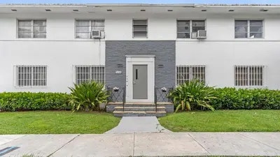 a white house with a white door and a yard at Brickell 4ever Apartment Beach 10 minutes Location in Miami