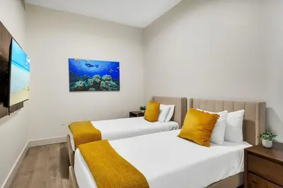 two beds in a small room with a tv at Front Bay View Terrace Amazing Pool in Hollywood