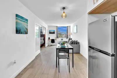a kitchen and living room with a table and a refrigerator at Deluxe modern 1 bedroom in south beach in Miami Beach