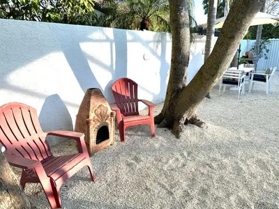 two chairs and a wood stove in the sand at Home in Miami in Miami