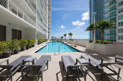 a swimming pool in a building with tables and chairs at Central ocean view 3 bedrooms in Miami W Parking in Miami