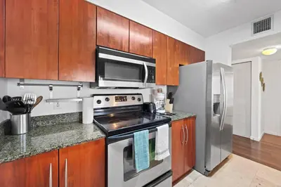 a kitchen with stainless steel appliances and wooden cabinets at Superb unit, centrally located with parking in Miami