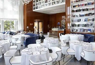 a dining room with white tables and white chairs at Emblematic unit at Icon in the heart of Brickell in Miami