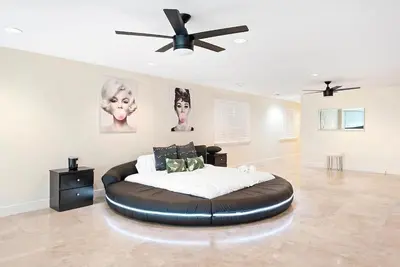 a bedroom with a large bed with a ceiling fan at Hollywood Luxurious Waterfall Villa with Incredible views in Hollywood