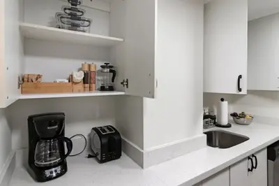 a kitchen with white cabinets and a blender on the counter at Roami at The Alamac in Miami Beach