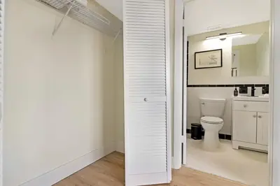 a white bathroom with a toilet and a sink at Roami at The Alamac in Miami Beach