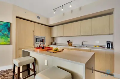 a kitchen with a counter and a bar with a stool at Insane Ocean View Balcony Beachfront Resort Pool in Hollywood