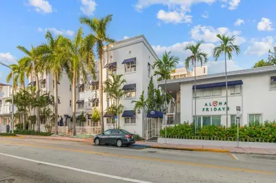 a car parked in front of a building with palm trees at Aloha Fridays in Miami Beach