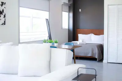 a bedroom with a bed and a white couch and a table at Franklin Suites South Beach in Miami Beach