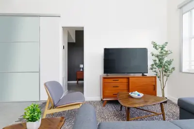 a living room with a couch and a tv at Franklin Suites South Beach in Miami Beach