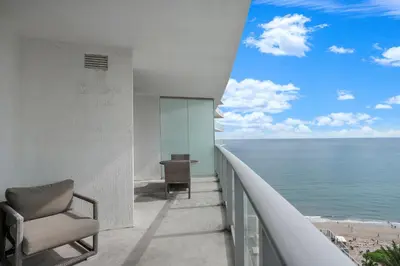 a balcony with a chair and a table and the ocean at 15th-Floor Luxury 1BR at Lyfe Resort with Ocean View in Hollywood