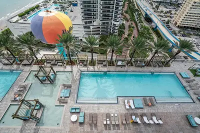 an overhead view of a swimming pool with a beach umbrella at 15th-Floor Luxury 1BR at Lyfe Resort with Ocean View in Hollywood