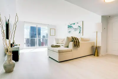 a white living room with a couch and a window at 2BR Penthouse with Unbeatable Water Views and Parking in Miami