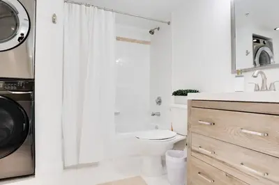 a white bathroom with a toilet and a shower at 2BR Penthouse with Unbeatable Water Views and Parking in Miami