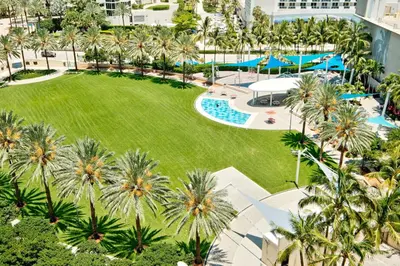 an aerial view of a resort with palm trees and a pool at MIAMI Collins Beach Apartments in Sunny Isles Beach