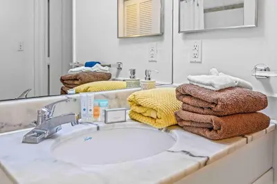 a bathroom with a sink and a mirror and towels at Amazing cozy Condo in Brickell Miami in Miami
