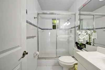 a white bathroom with a shower and a toilet at Walk to Hollywood Beach Luxury 4BR Villa in Hollywood