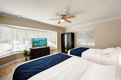 a bedroom with two beds and a ceiling fan at Walk to Hollywood Beach Luxury 4BR Villa in Hollywood