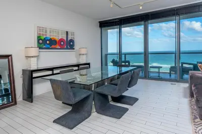 a dining room with a glass table and chairs at Oceanfront Private Residence at South Beach - 828 in Miami Beach