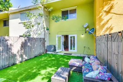a backyard with two couches and a fence at Opa-locka Townhome, 15 Mi to Miami Beach! in Opa-locka