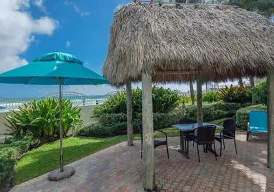 a patio with a table and a straw umbrella at Miami Hollywood Gorgeous 2BD Awesome Ocean View in Hollywood