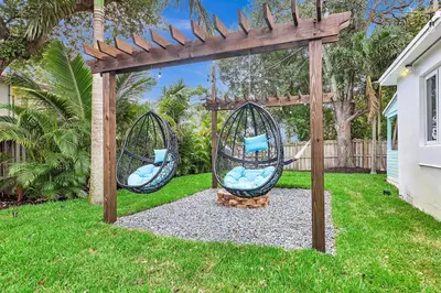 two swings under a pergola in a yard at Quiet and secluded 4 bedroom home! in Fort Lauderdale