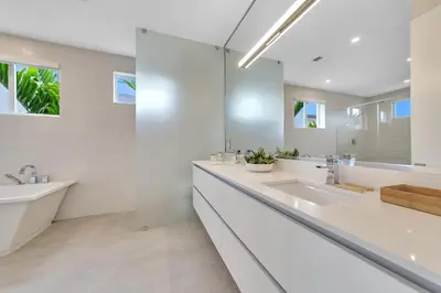a white bathroom with two sinks and a mirror at Your Dream Home in Coral Ridge in Fort Lauderdale