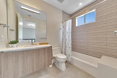 a bathroom with a toilet and a sink and a mirror at Your Dream Home in Coral Ridge in Fort Lauderdale