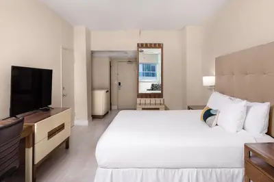 a bedroom with a large bed and a flat screen tv at Sherry Frontenac Oceanfront in Miami Beach