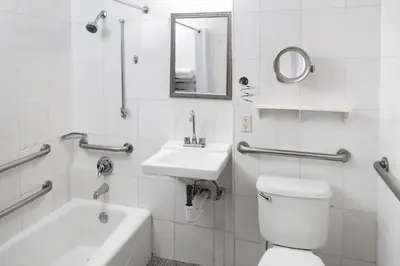 a bathroom with a toilet and a sink and a mirror at Sherry Frontenac Oceanfront in Miami Beach