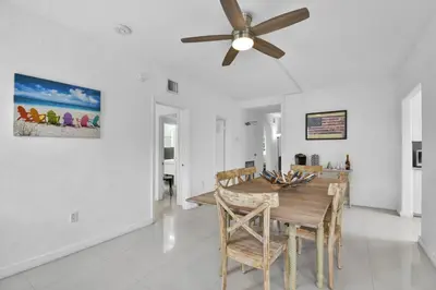 a dining room with a ceiling fan and a wooden table at Seaheights Villa in Miami Beach