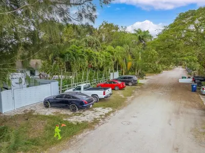 a group of cars parked on the side of a dirt road at Farmhouse Miami in Miami