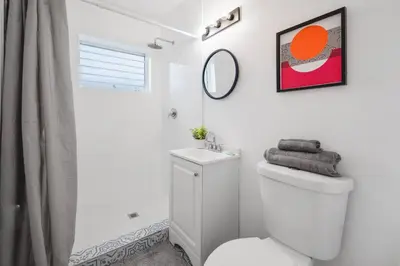 a white bathroom with a toilet and a mirror at Beautiful Apt 2/2 Near The Beach in Miami