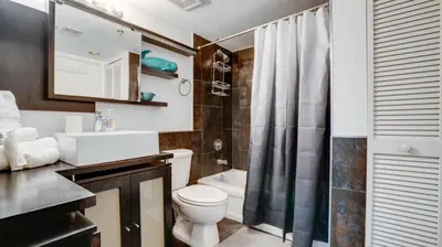 a bathroom with a toilet and a sink and a shower at Warm and Tailored 1BR w Pool Hot tub GYM Parking in Miami