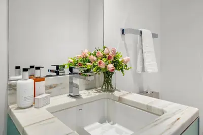 a vase of flowers sitting on a sink in a bathroom at Ocean View Residence at South Beach -514 in Miami Beach