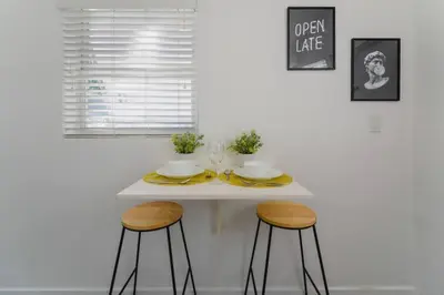 a white table with two stools in a kitchen at Wonderful Studio Residence 15 min from the beach in Miami