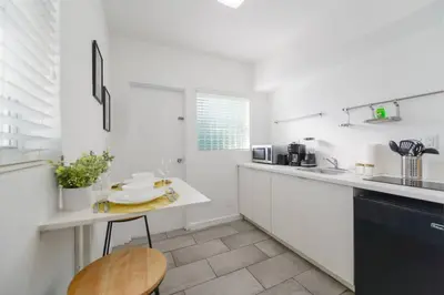 a white kitchen with a counter and a table at Wonderful Studio Residence 15 min from the beach in Miami