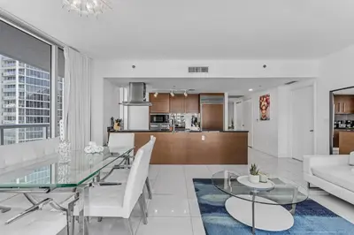 a living room and kitchen with a glass table at Luxurious Condo at ICON with Views in Miami