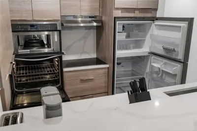 a kitchen with an empty refrigerator and an open oven at Lauderdale Modern 1 Bedroom 1 Bathroom with Private Backyard in Fort Lauderdale
