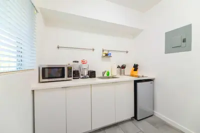a kitchen with white cabinets and a microwave at Lovely Studio A Few Steps From The Beach in Miami