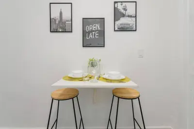 a white table with two stools in a room at Great Studio Residence 15 min from the beach in Miami
