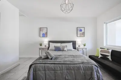 a white bedroom with a large bed and a couch at Great Studio Residence 15 min from the beach in Miami