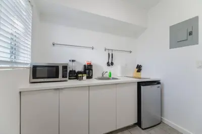 a white kitchen with a microwave and a sink at Great Studio Residence 15 min from the beach in Miami