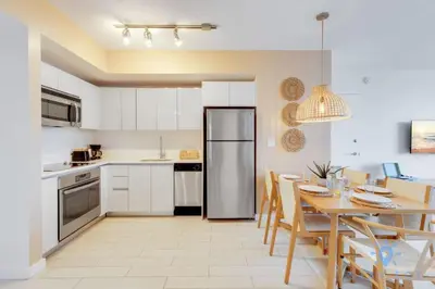 a kitchen and dining room with a table and a refrigerator at Pool - Apartment with Balcony - Gym - Near Beach in Hallandale Beach