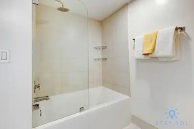 a white bathroom with a tub and a shower at Pool - Apartment with Balcony - Gym - Near Beach in Hallandale Beach