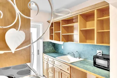 a small kitchen with wooden cabinets and a sink at Sea Angel in Hollywood Beach