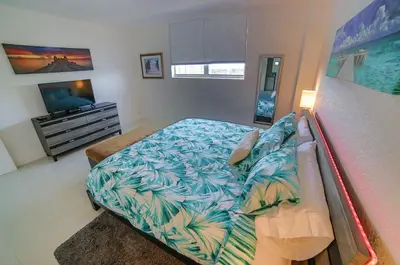 a bedroom with a bed and a television at Beautiful penthouse condo with stunning views of both ocean and city in Hollywood