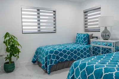 a bedroom with a bed and a chair and windows at Welcome to 305 Rentals in Miami